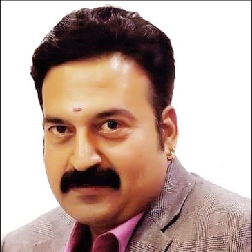 Portrait of a man with a mustache and blazer against a white background.