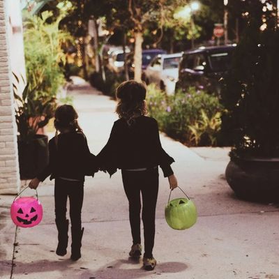 Two girls trick or treating.