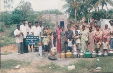 People gathered outdoors with water containers.