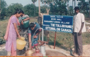 People collecting water at a village borewell in India.