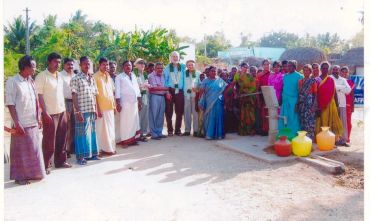 Group of people gathered outdoors in a rural area.