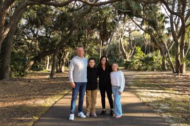 Family posing on a wooded path.