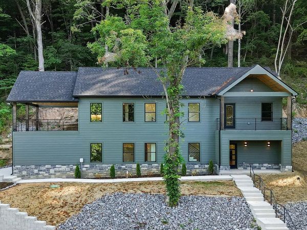 Modern house with a gray exterior in a wooded area.