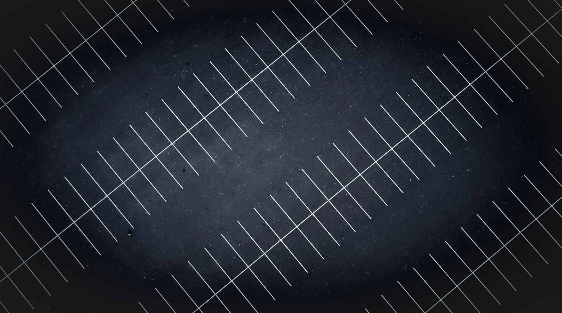 Empty parking lot with white-lined spaces at night.
