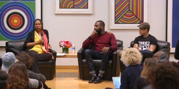 Panel discussion with three speakers in a colorful room.