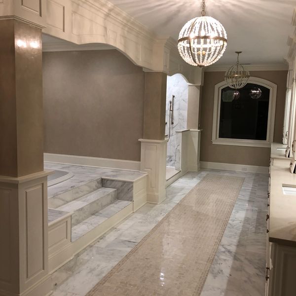 Luxurious bathroom with marble floors, elegant lighting, and a spacious layout.