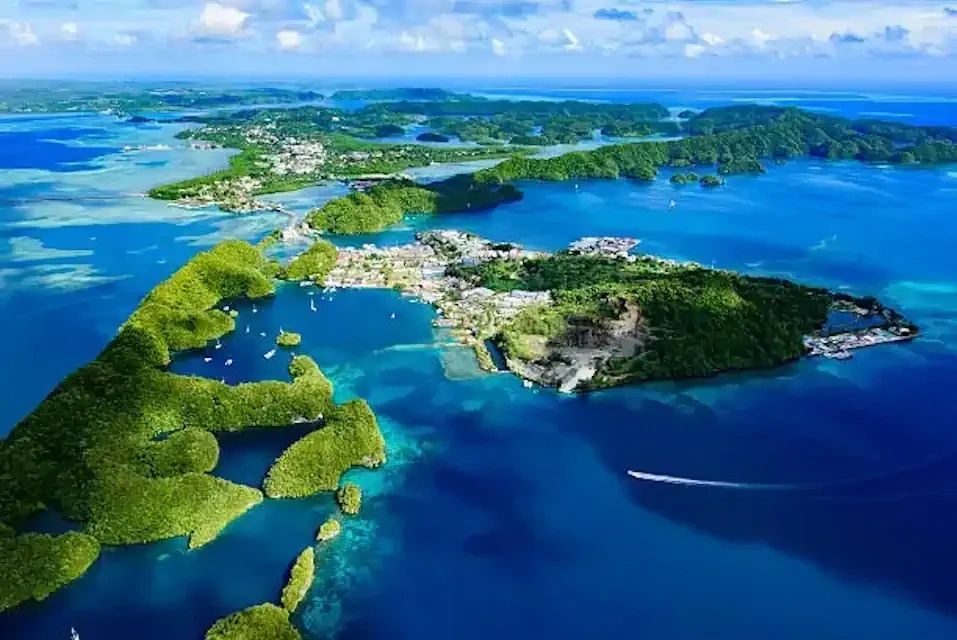 Aerial view of a lush island surrounded by blue waters.