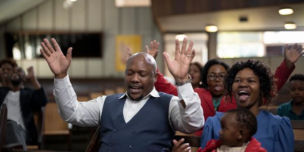 People worshiping with raised hands in a church.