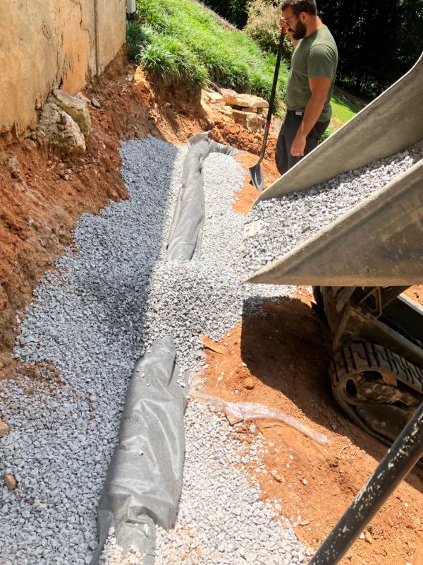 Man working on gravel drainage installation.