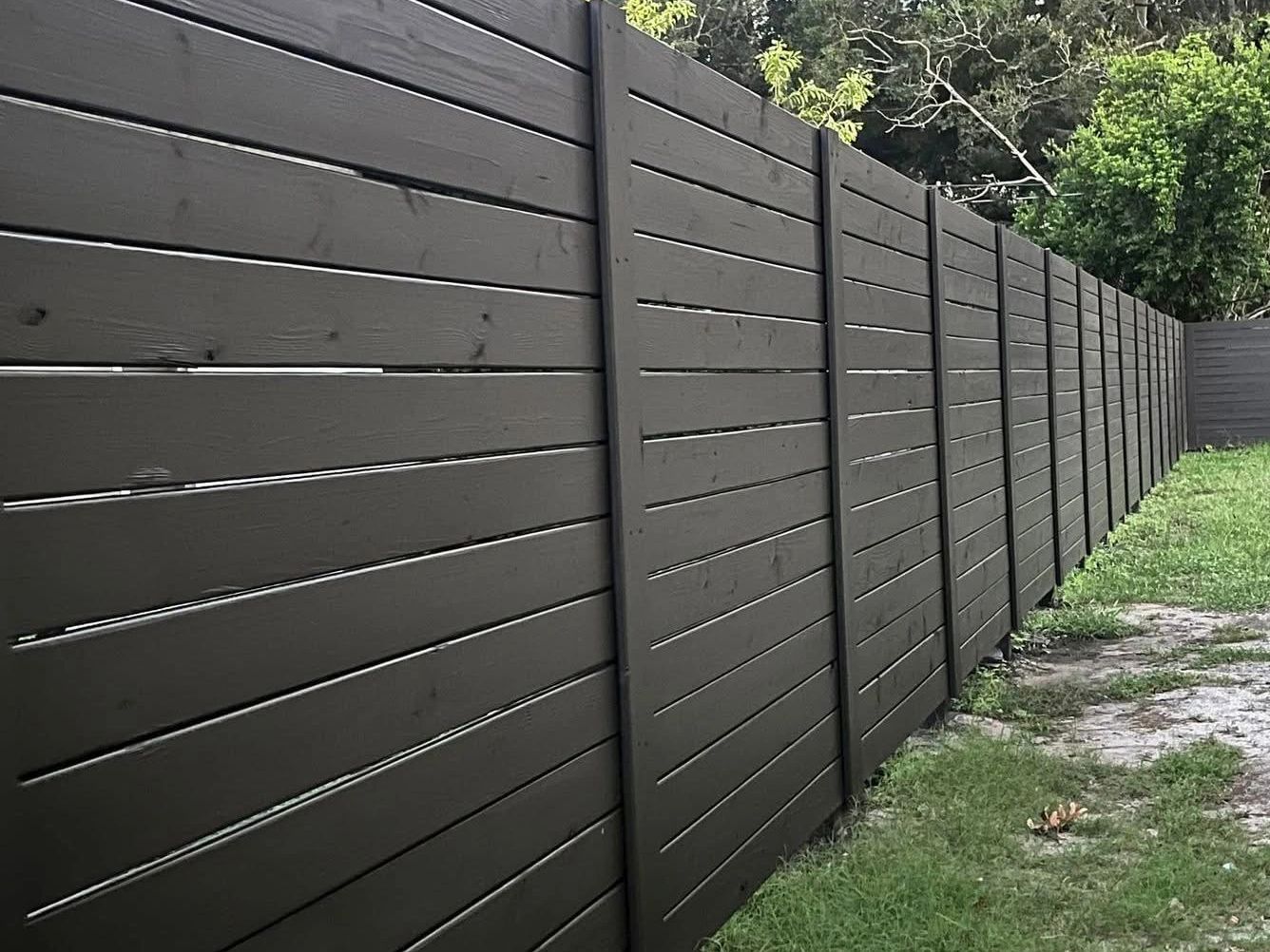 Horizontal deck board fence painted black