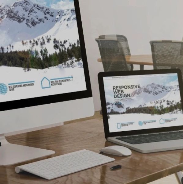 Desktop and laptop showing responsive web design with mountain scenery.