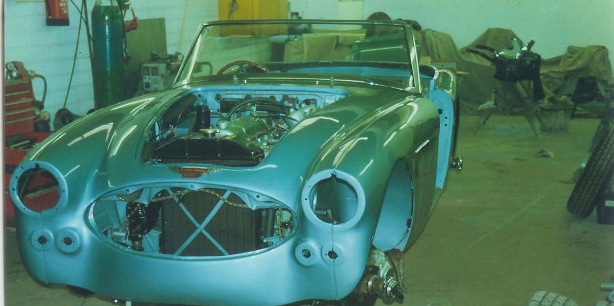 Restoration of a classic convertible car in a workshop.