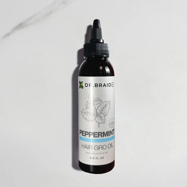 Bottle of peppermint hair growth oil on a white surface.