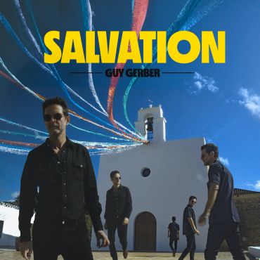 Band members stand in front of a white church under a blue sky.