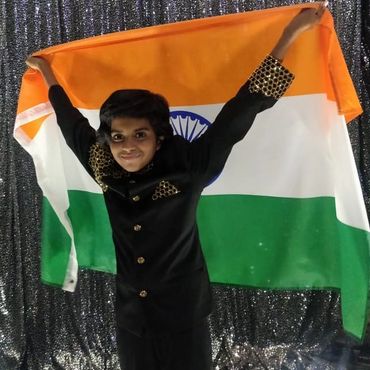Child holding Indian flag with pride.