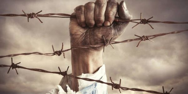 A hand gripping barbed wire symbolizing struggle and resistance.