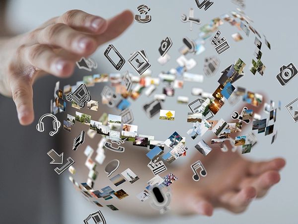 Hands interacting with floating digital icons and images.
