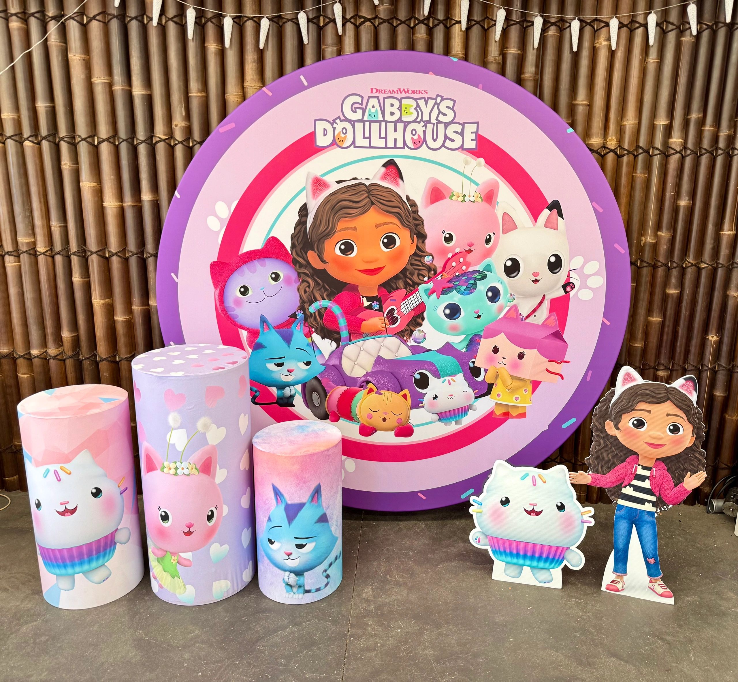 Colorful Gabby's Dollhouse display with characters and decorations on bamboo background.