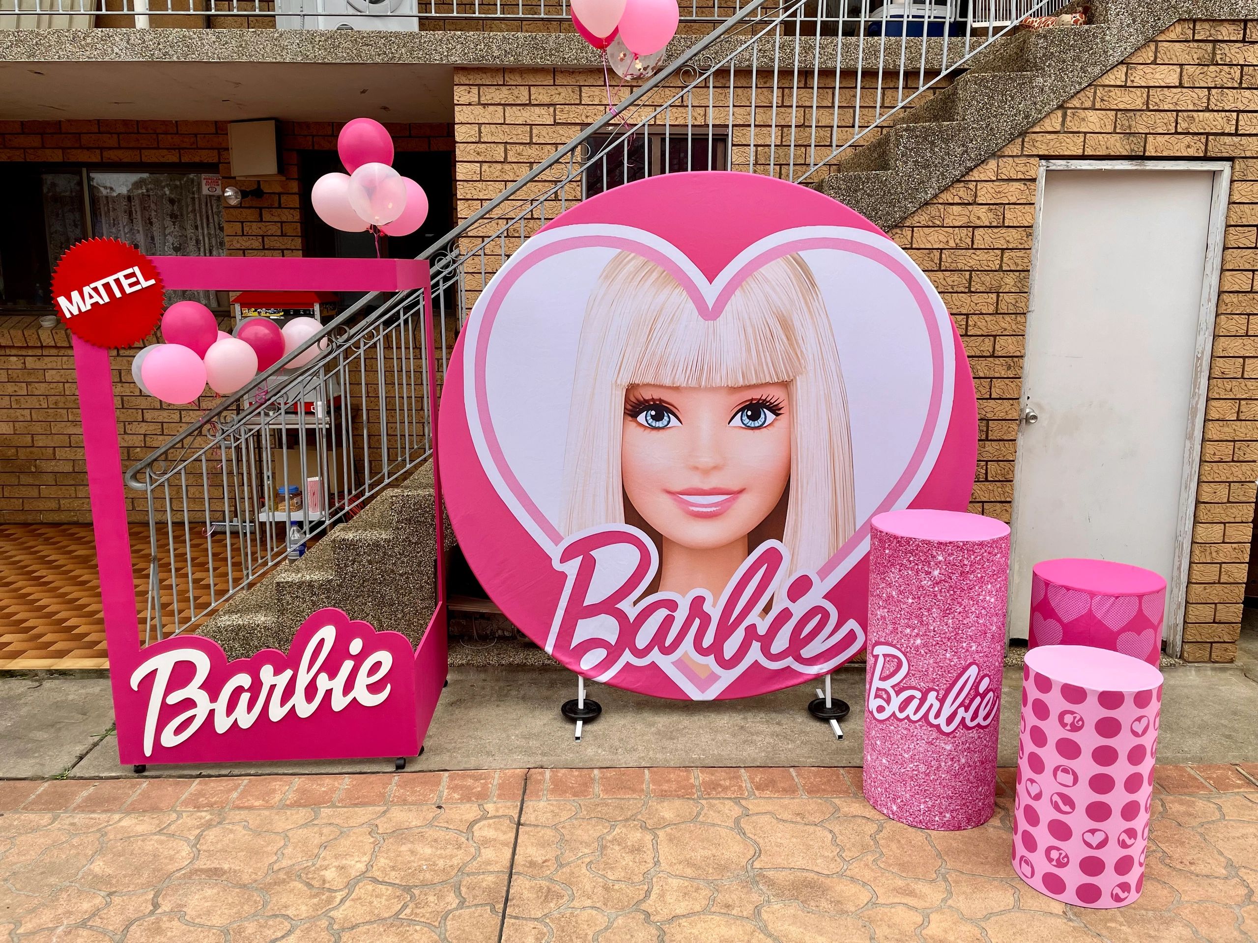 Barbie-themed photo booth setup with pink decorations and balloons.