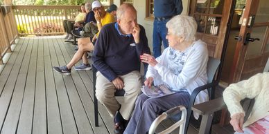 Two people talking on the porch