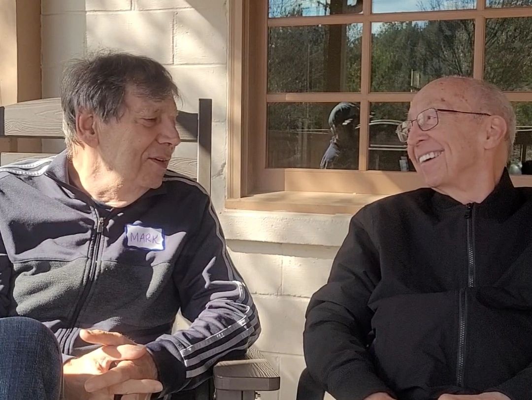 Two men talking on the porch