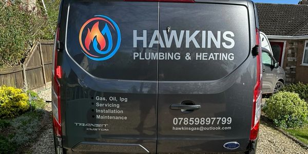 Rear view of a Hawkins Plumbing &amp; Heating service van with contact details.