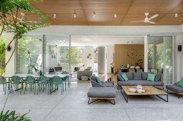 Modern open living and dining area with glass walls.