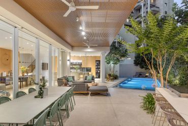 Modern outdoor patio with pool and seating areas.