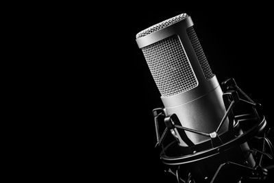 Close-up of a professional studio microphone on a black background.