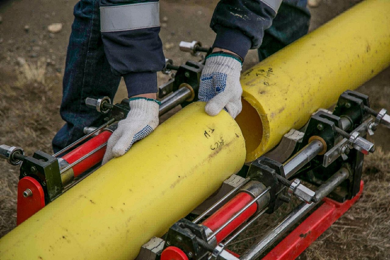 a person holding yellow pipes