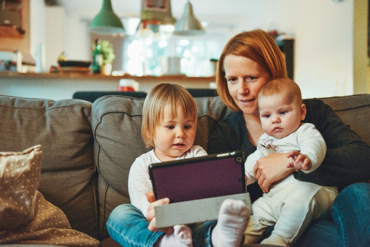 a woman sitting with her children on a sofa a woman sitting with her children on a sofa