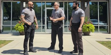 Three armed Sacramento Security Guards standing in front of a building providing a safe place.