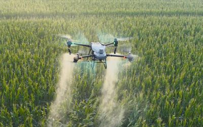 Spray drone applying fertliser to farm crops