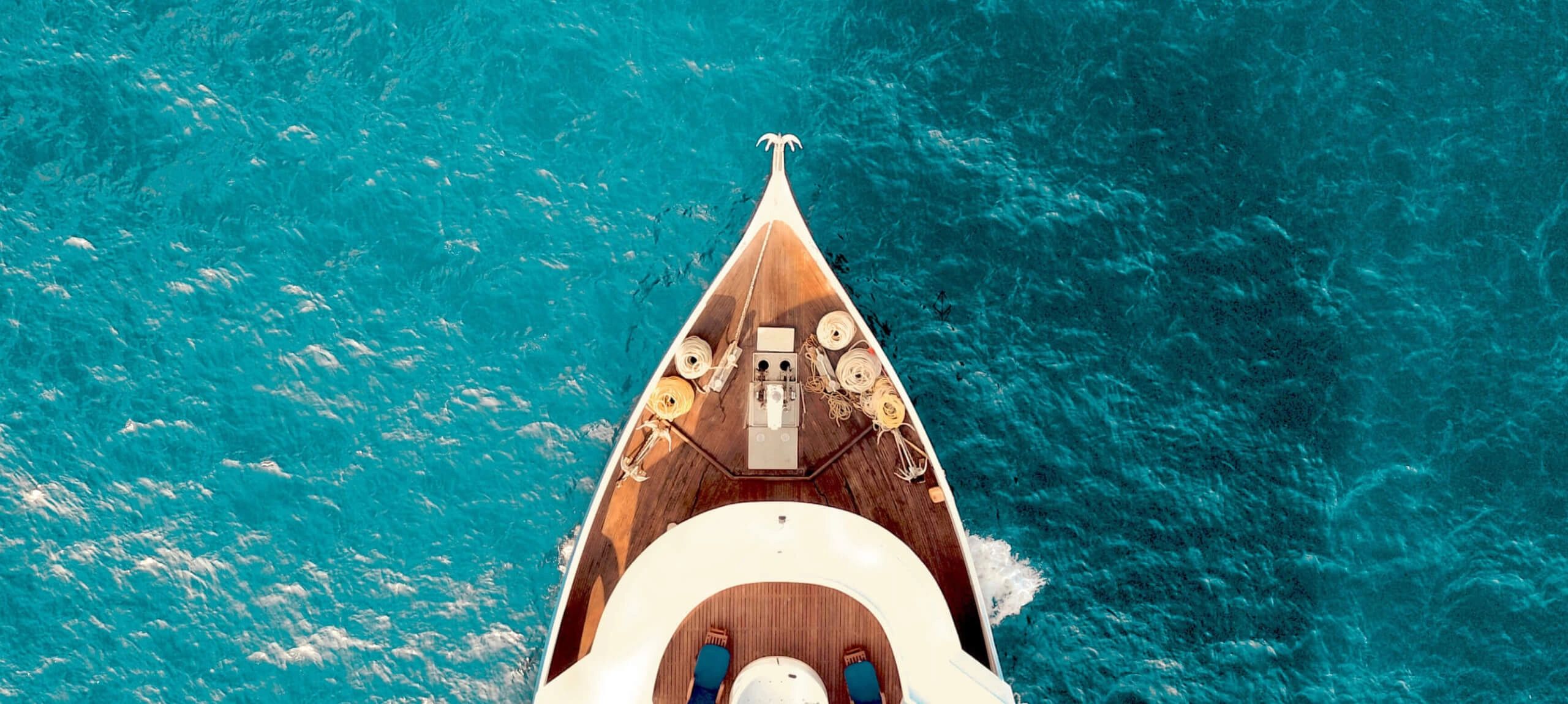 Stack of books next to pencils in a holder and a camera.