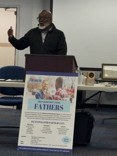 Man speaks at a podium about recruiting local fathers in Portsmouth.