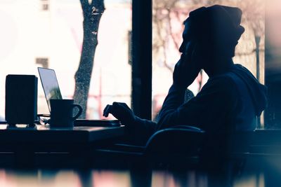 Woman alone in cafe working on laptop