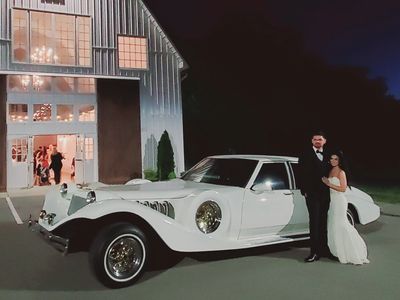 A newlywed couple standing next to Excaliber from Sedan on Demand, Nashville Luxury Transportation.
