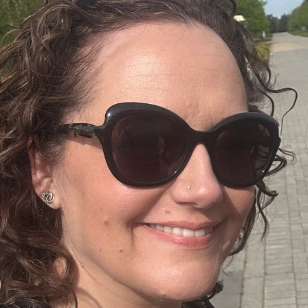 Woman smiling wearing large black sunglasses.