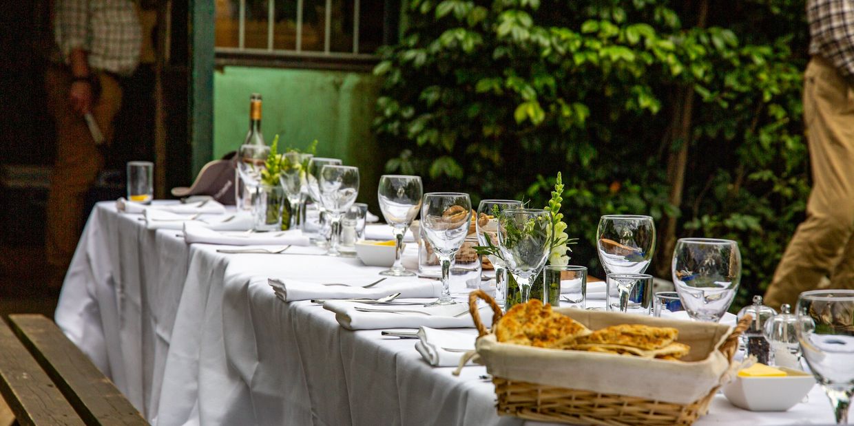 Dinner table with glassware by the river for corporate day fly fihsing 