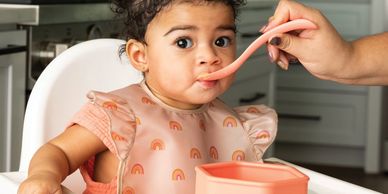 Toddler con babero impermeable en la hora de comida.