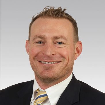 Professional headshot of a smiling man in a suit and striped tie.