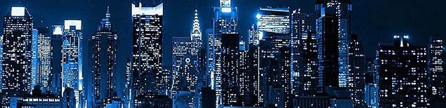 A night time city skyline with offices lit up.