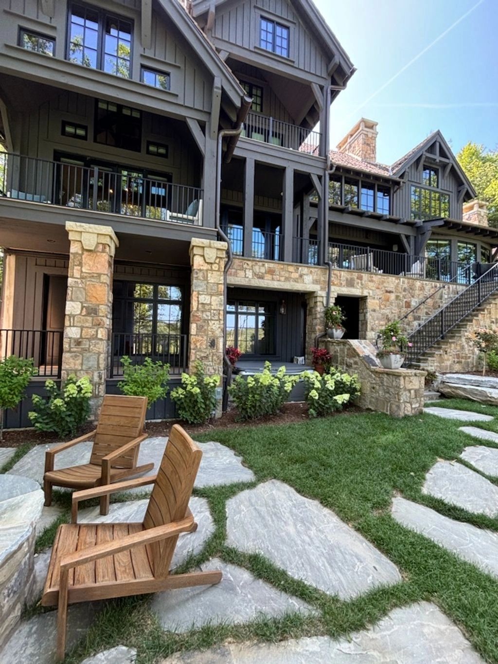 Rustic stone and wood house with a cozy backyard seating area.