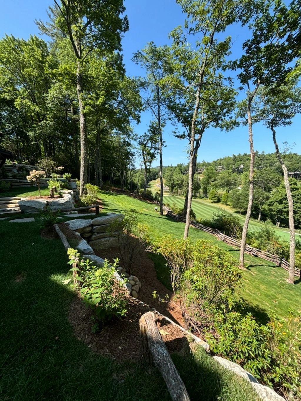 Scenic backyard view overlooking a lush golf course under a clear blue sky.
