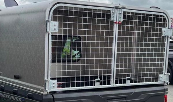 Metal dog crate mounted on a vehicle.