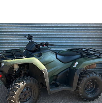 Green all-terrain vehicle (ATV) parked outdoors.