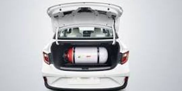White car with trunk open showing a gas cylinder inside.
