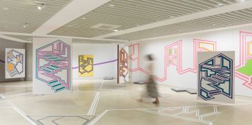 Abstract geometric wall murals in a modern gallery.