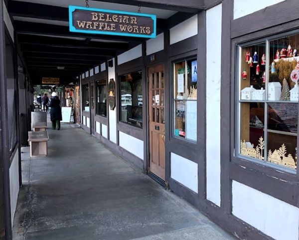 A long outdoor corridor with store fronts.