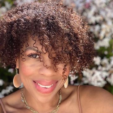 A woman with brown short curly hair